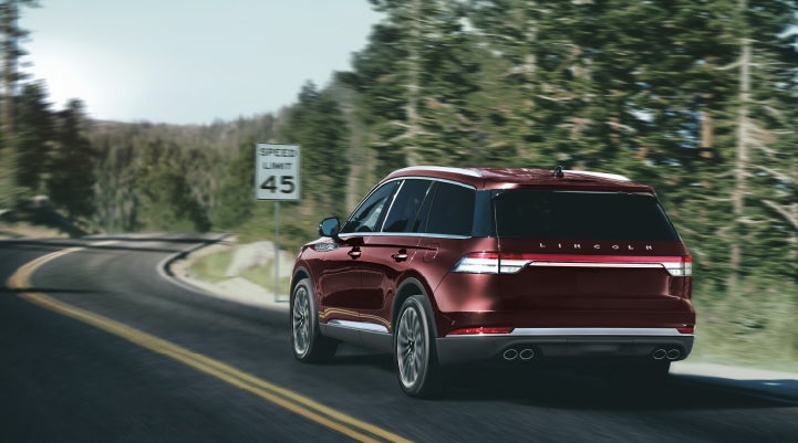 A 2024 Lincoln Aviator® SUV is being driven on a winding mountain road | Lincoln Demo 3 in Wooster OH