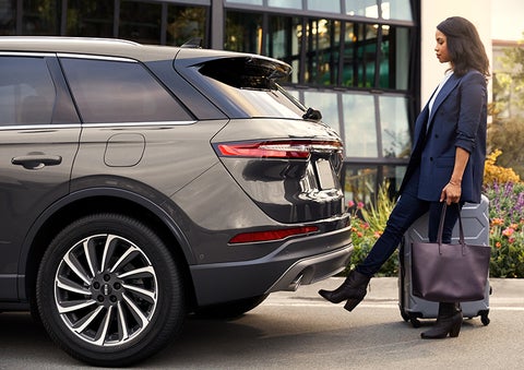 A woman with her hands full uses her foot to activate the available hands-free liftgate. | Lincoln Demo 3 in Wooster OH